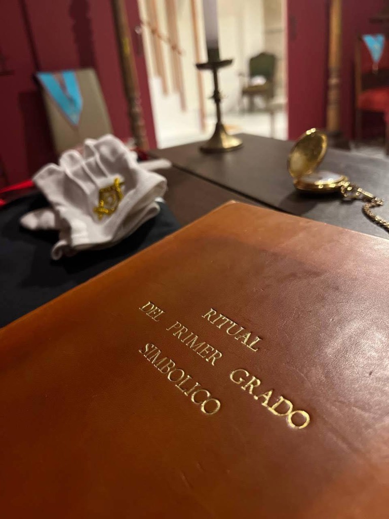 Libro encuadernado en cuero del Ritual del Primer Grado Simbólico con guantes masónicos y reloj de bolsillo